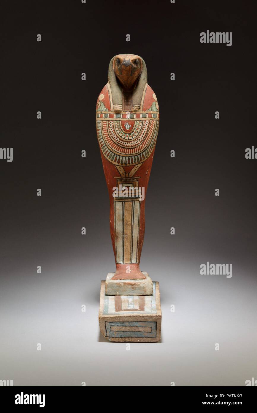 Figura funeraria di Qebehsenuef. Dimensioni: H. 39,7 cm (15 5/8 in.); W. 11,5 cm (4 1/2 in.); D. 25,7 cm (10 1/8 in.). Data: ca. 400-30 A.C.. Questo falcon-intitolata La figura rappresenta il dio Qebehsenuef, che hanno protetto gli intestini. Egli è uno dei quattro cosiddetti figli di Horus che sono spesso rappresentati come mummie, ciascuna con una diversa testina (per le altre tre statuette appartenenti allo stesso gruppo, vedere 12.182.37a-b, d). I figli di Horus erano divinità che hanno protetto gli organi interni e sono probabilmente meglio conosciuto da loro rappresentazioni sui coperchi dei vasi canopi che conteneva mummificato vis Foto Stock