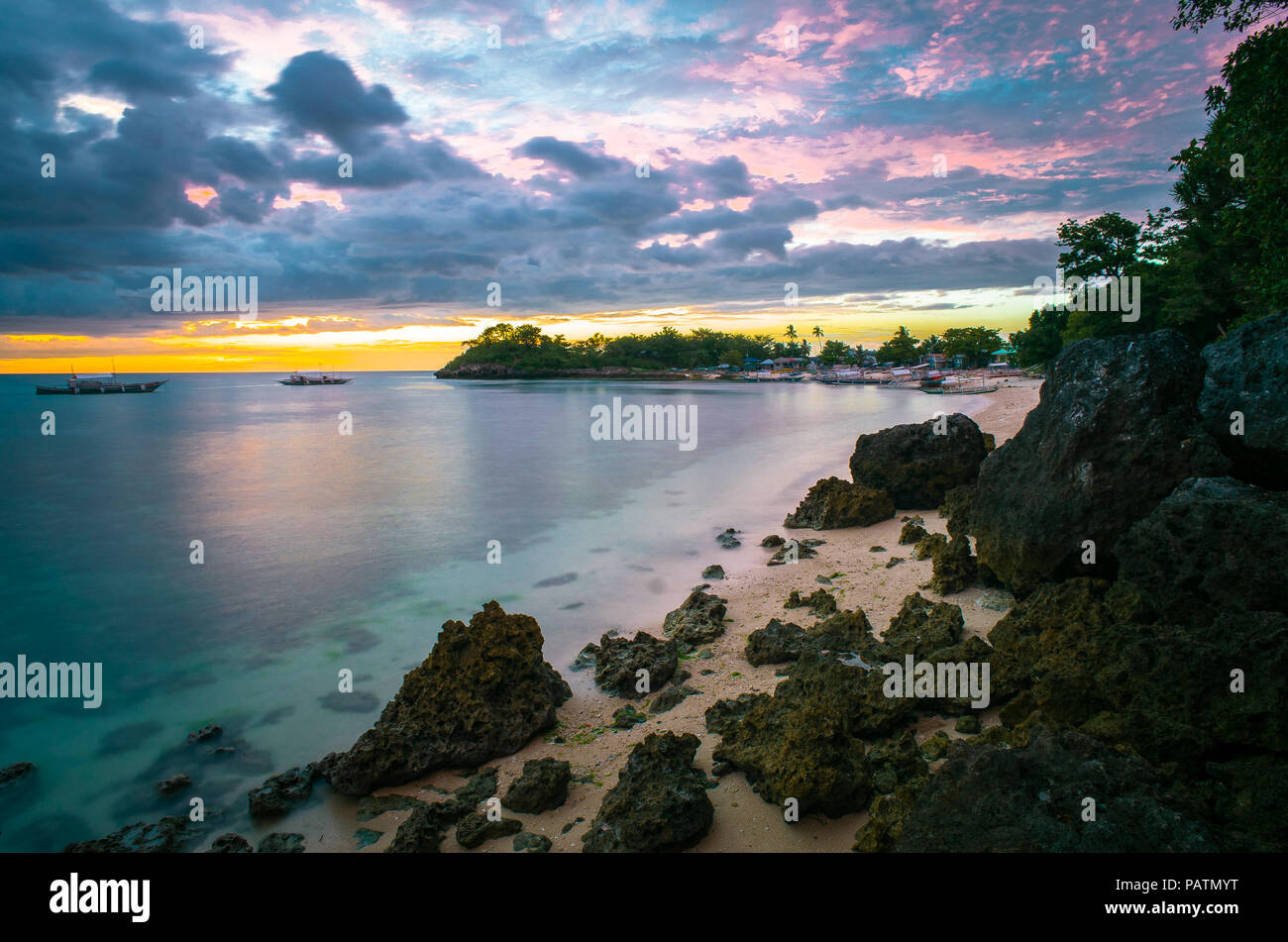 Rosa colorato tramonto Cielo sopra uno sperone isola paradisiaca spiaggia e mare - Langob, Malapascua, Cebu - Filippine Foto Stock
