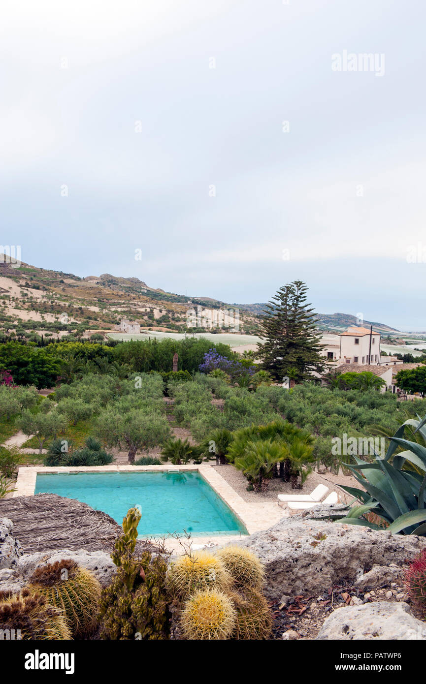 La piscina e i giardini a Azienda Agricola Mandranova, un agriturismo hotel e di lavoro fattoria di oliva al di fuori della città di Agrigento in Sicilia meridionale. Foto Stock