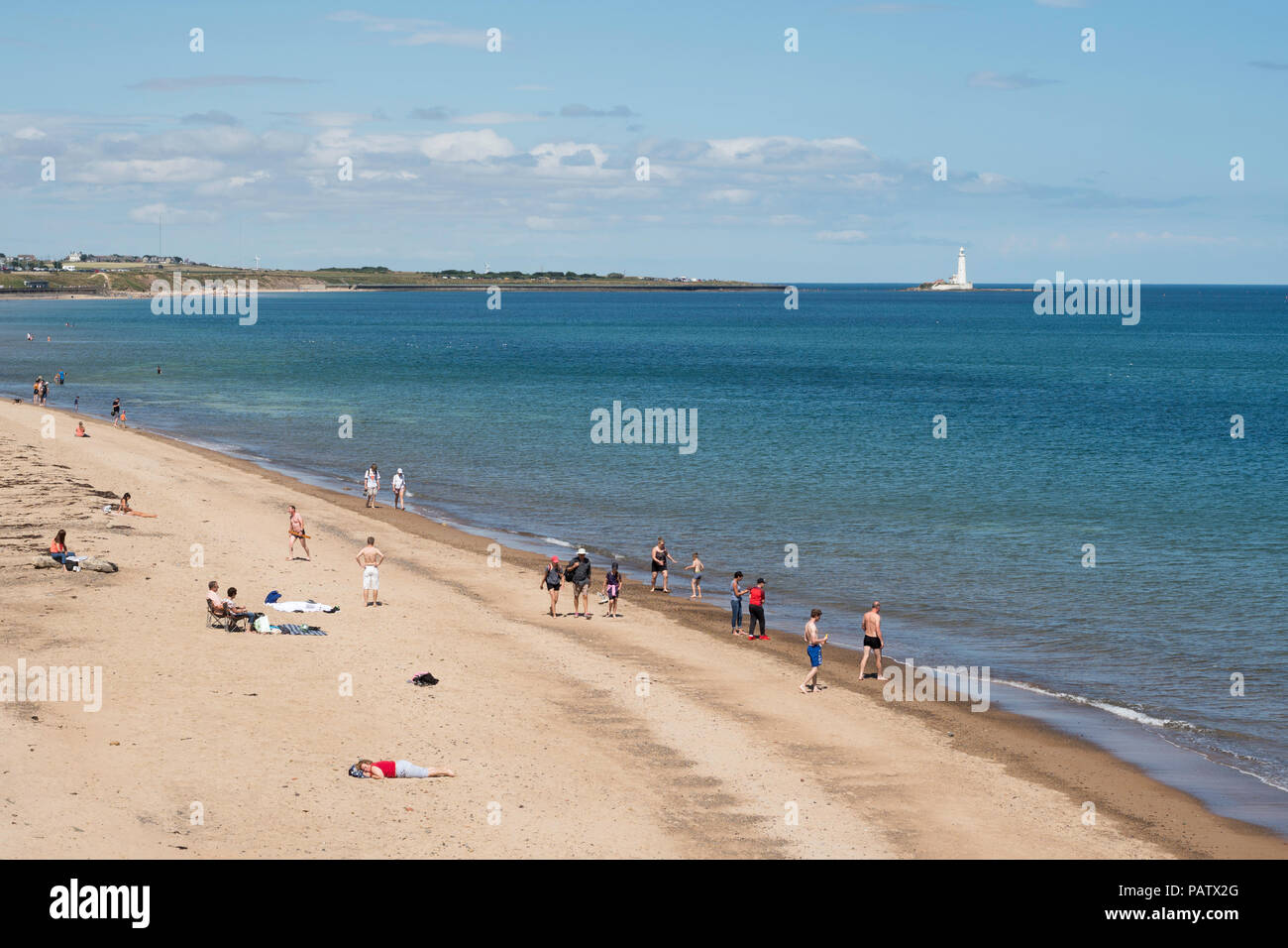 Per coloro che godono di un sole estivo a Whitley Bay Beach, con St Mary's Island in background, North East England, Regno Unito Foto Stock