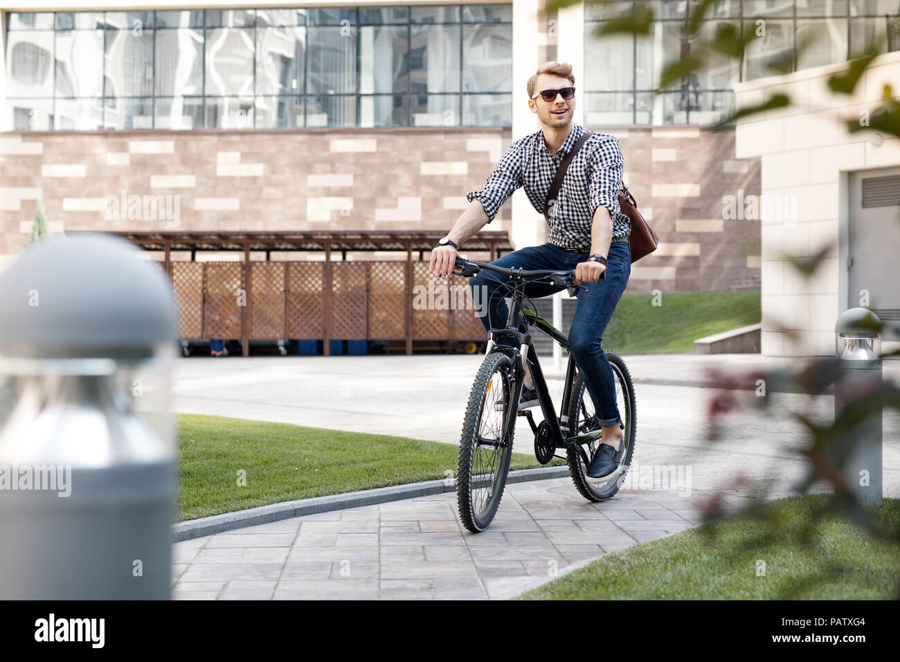 Felice l'uomo positivo utilizzando una bicicletta Foto Stock