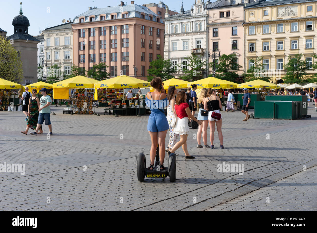 Giovane donna su una scheda Segway nella piazza principale,Cracovia, in Polonia, in Europa. Foto Stock