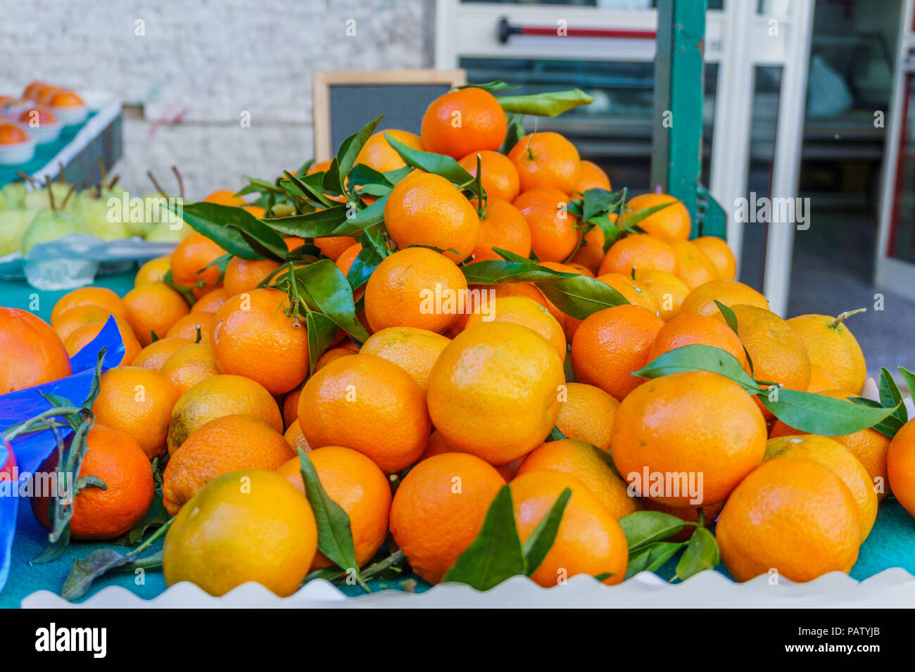 Cumulo di maturi freschi Arance Mandarini con foglie verdi sul mercato Foto Stock