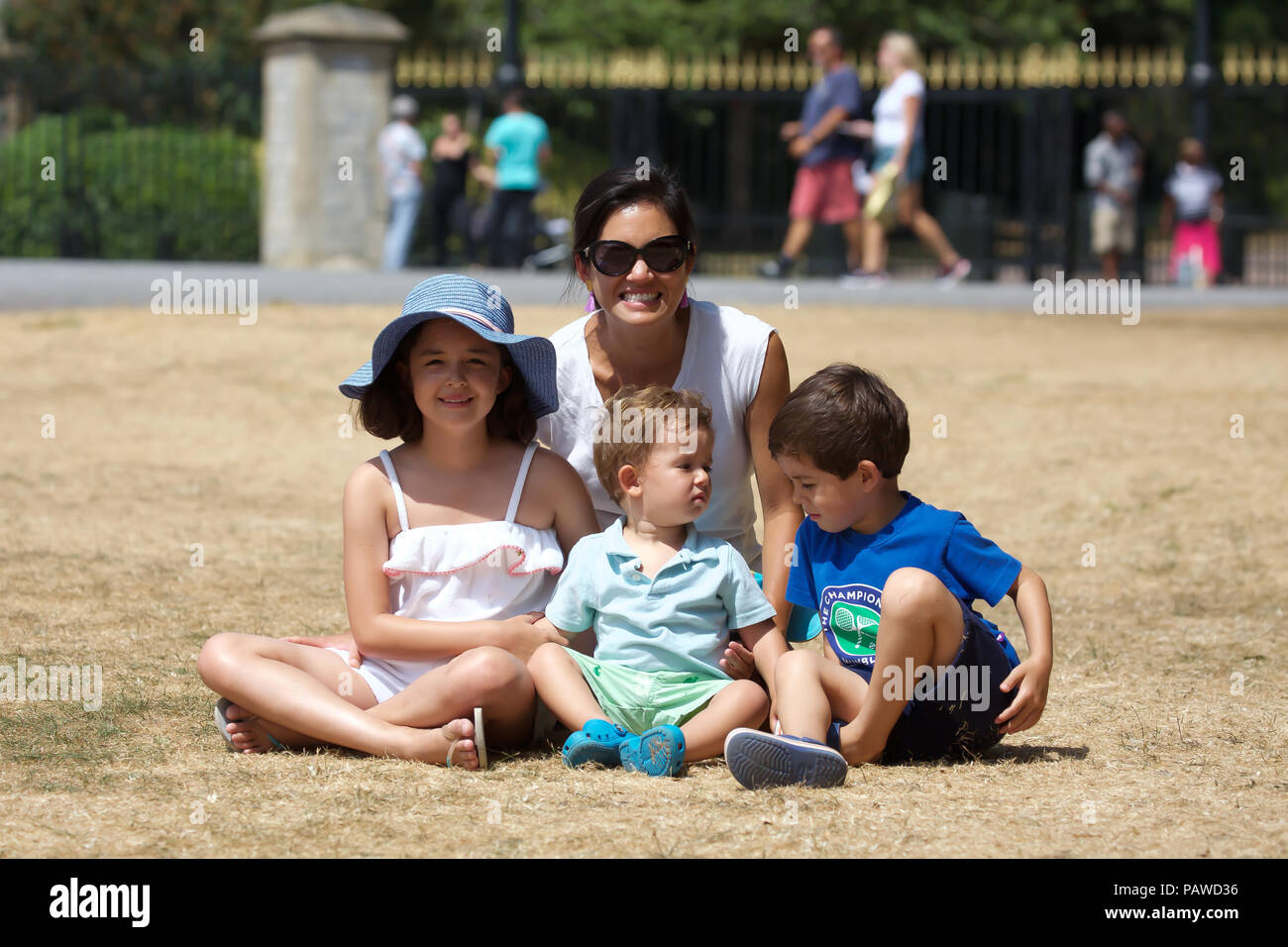 Windsor,UK,25 Luglio 2018,una famiglia siede sull'erba bruciata dal lungo cammino come il caldo continua a Windsor, la previsione è per il sole e il calore che è venuto da Africa e Mediterraneo. La gente viene ricordato per rimanere fuori del sole da 11-3pm, mantenere idratato e tenere le finestre e le porte chiuse a casa. Credito Larby Keith/Alamy Live News Foto Stock