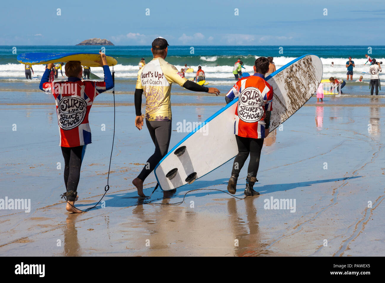 Polzeath Beach, Cornwall, Regno Unito. Il 25 luglio 2018. Testa di surfisti per le onde su una calda e soleggiata giornata a Polzeath su North Cornwall dalla costa atlantica, Credito: Mark Richardson/Alamy Live News Foto Stock