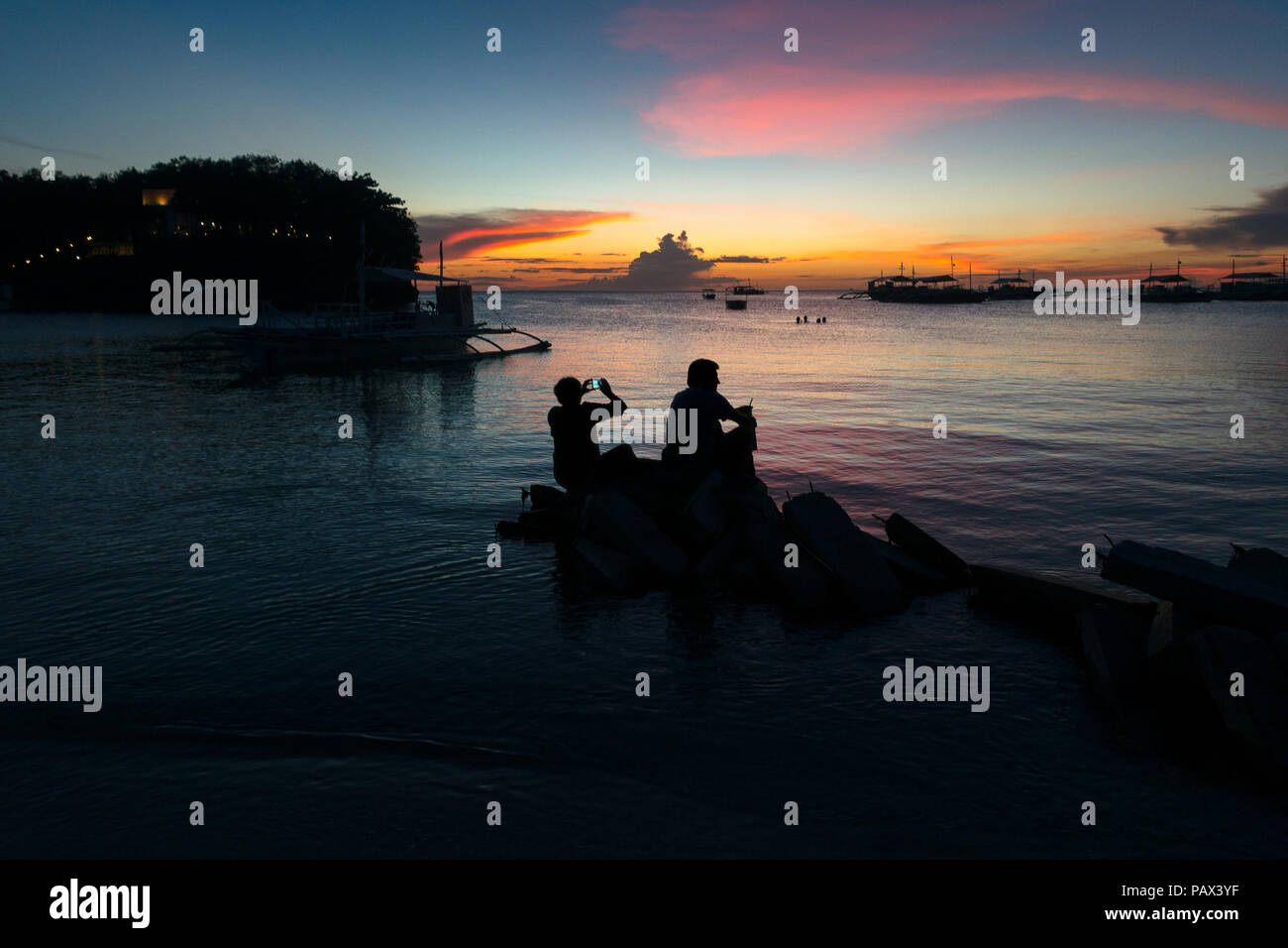 Silhouette di pensionati anziani matura tenendo sunrise foto sull isola tropicale beach - Panglao, Bohol - Filippine Foto Stock