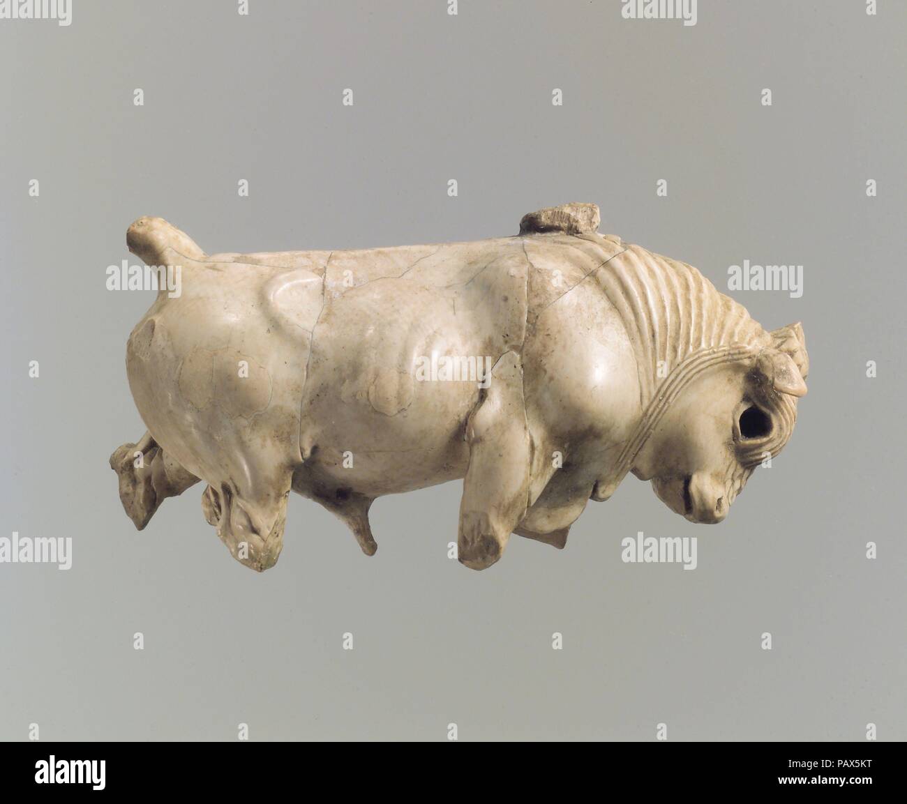 Mobili o box cosmetico lapide scolpiti a tutto tondo con estensione bull. Cultura: Assiro l. Dimensioni: 2,89 x 1,46 x 0,94 in. (7,34 x 3,71 x 2,39 cm). Data: ca. 8-VII secolo A.C. Questa estensione bull è stato trovato con quattro esempi simili in una casa privata a ridosso della cinta muraria a Nimrud, dove è stato probabilmente preso come recuperare da un complesso di palazzo quando esse sono state saccheggiate durante la definitiva sconfitta di Assiria alla fine del settimo secolo A.C. Scolpiti a tutto tondo, questo pezzo sarebbe stato originariamente fissato ad una base circolare, forse in linea con gli altri tori di estensione, e fissato ad un uppe Foto Stock