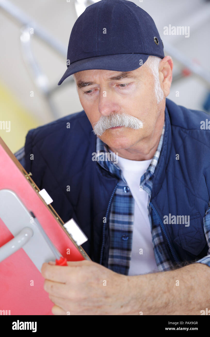 I vecchi fabbro ispezione di un sistema di bloccaggio di porte in ufficio Foto Stock