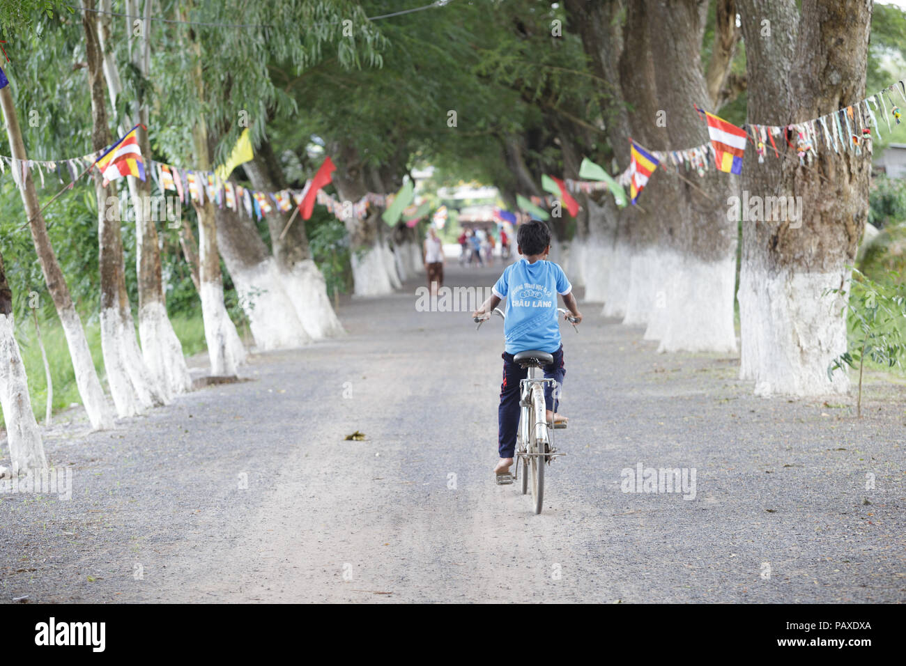 Popolo vietnamita, donna o bambino con cappello conico sulla bicicletta in un Giang, sud del Vietnam Foto Stock