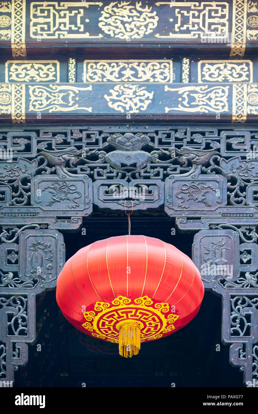 Rosso lanterne cinesi appeso su una porta decorata in LuoHanSi tempio buddista, Chongqing Cina Foto Stock