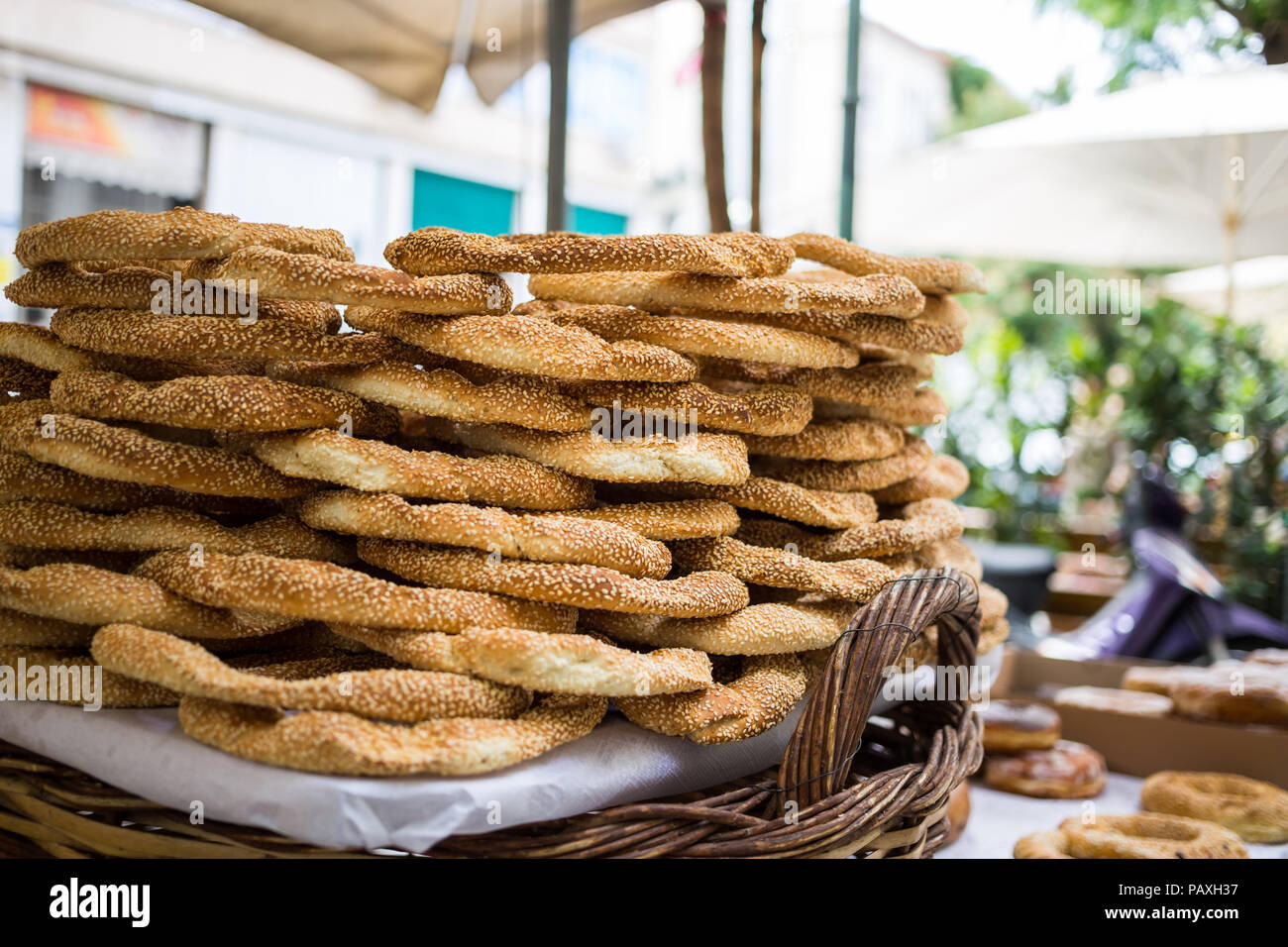 Cibo tradizionale concetto. Il vassoio pieno di greco tradizionale appuntamento di sesamo gli anelli di pane, visualizzati in un mercato di strada con sfondo bokeh di fondo. Foto Stock