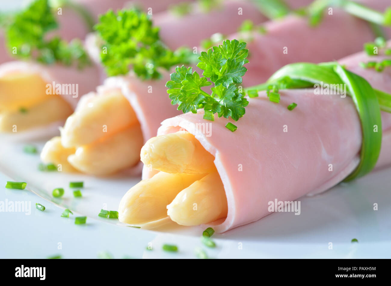 Laminati prosciutto bollito farcito con asparagi Foto Stock