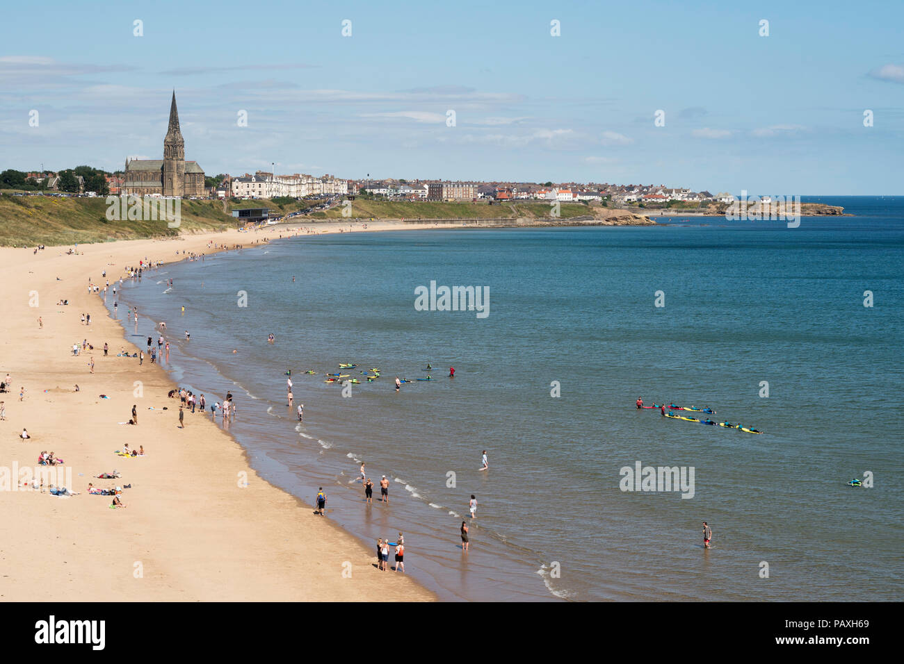 Per coloro che godono di un sole estivo sul Longsands Tynemouth beach, Cullercoats in background, North East England, Regno Unito Foto Stock