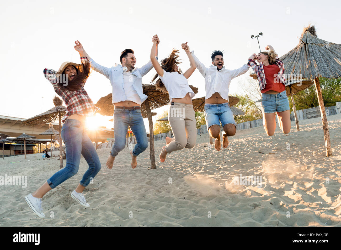 Il gruppo di amici di felice festa sulla spiaggia Foto Stock