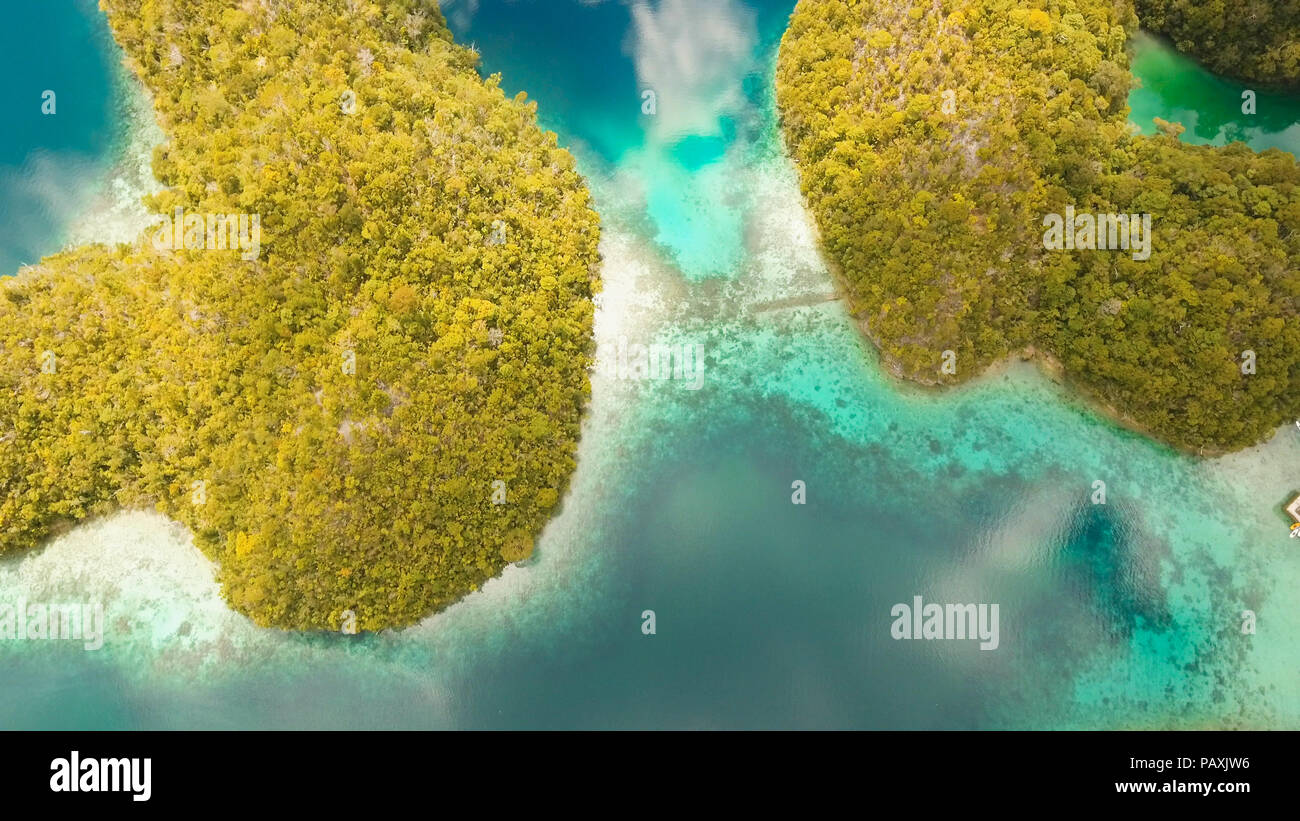 Vista aerea: spiaggia, isola tropicale, Baia Mare e laguna, Siargao. Paesaggio tropicale hill, nuvole e montagne rocce con la foresta pluviale. Acque azzurre della laguna. Paesaggio Shore Bay. Concetto di viaggio. Foto Stock