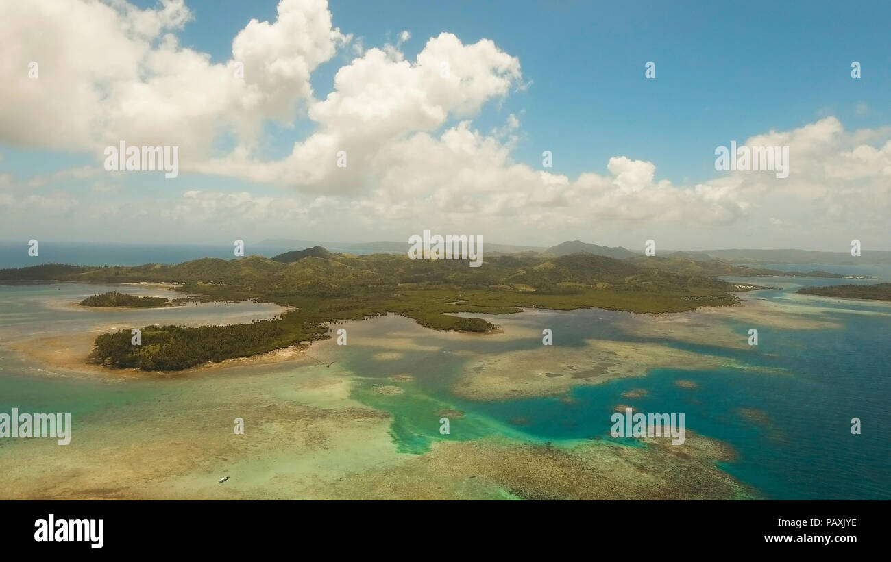 Vista aerea: spiaggia, isola tropicale, Baia Mare e laguna, Siargao. Paesaggio tropicale hill, nuvole e montagne rocce con la foresta pluviale. Acque azzurre della laguna. Paesaggio Shore Bay. Video dell'antenna.Seascape. Foto Stock
