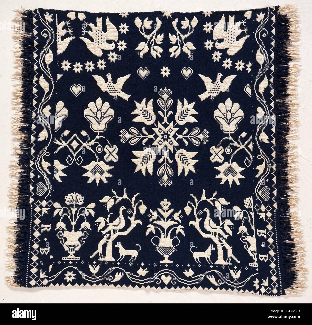 Presepe o bambola coverlet. Cultura: American. Dimensioni: 39 1/4 x 30 1/2 in. (99,7 x 77,5 cm). Maker: Probabilmente David Daniel Haring (1800-1889). Data: ca. 1836. Questo blu scuro di lana e cotone non tinta panno doppio culle o bambola coverlet è tessuto in un unico pannello. Anche se il pezzo è destinata a essere visualizzato con due R + B blocchi al piede, è tessuto lateralmente. La naturale frange su lati destro e sinistro sono le estremità del taglio fili di ordito. L'animale e motivi floreali sono tipici di Haring di lavoro. Museo: Metropolitan Museum of Art di New York, Stati Uniti d'America. Foto Stock