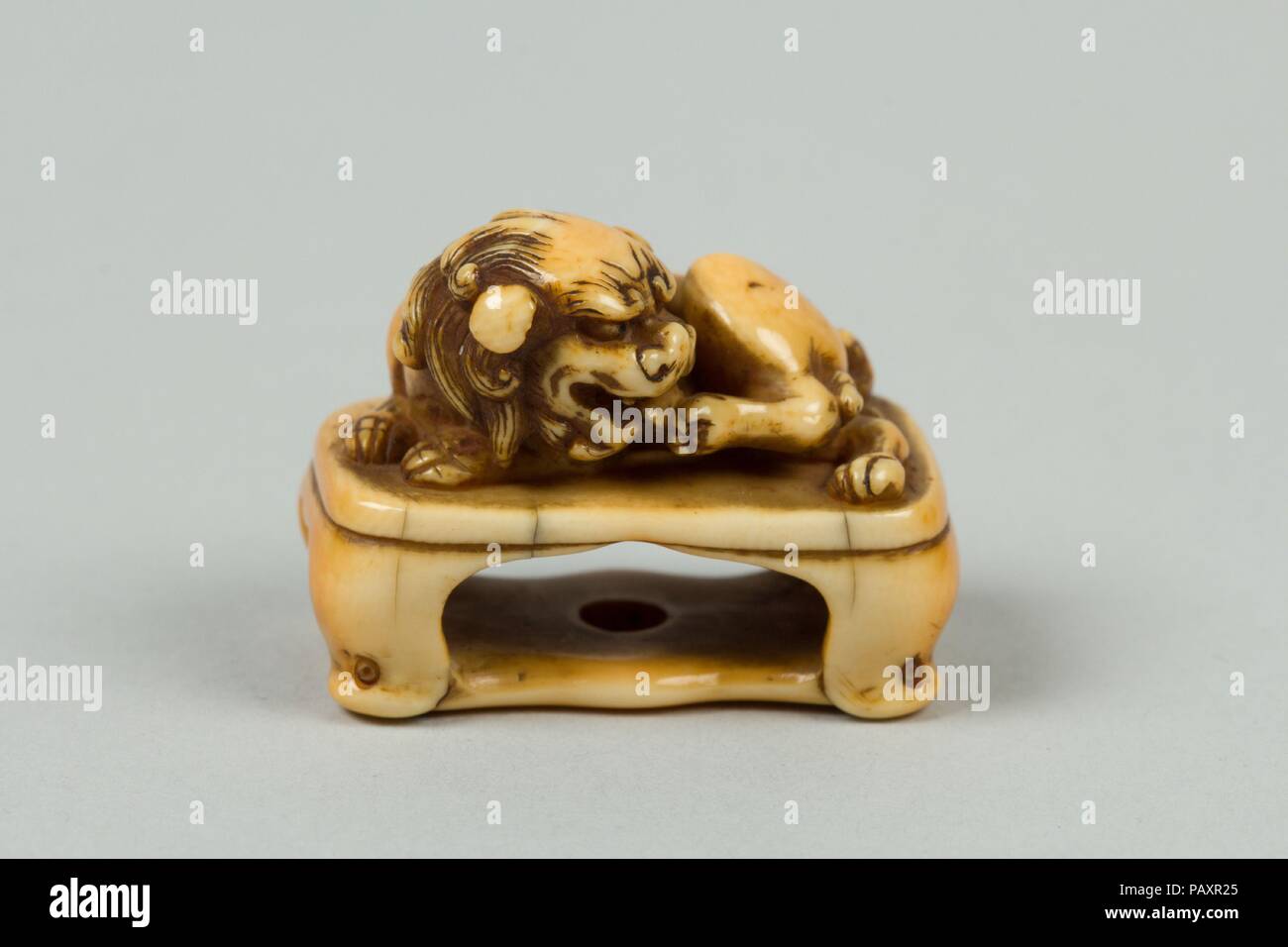 Netsuke di Lion su un cavalletto. Cultura: il Giappone. Dimensioni: H. 1. (2,5 cm); W. 1 1/4 in. (3.2 cm); D. 3/4 in. (1.9 cm). Data: del XIX secolo. Museo: Metropolitan Museum of Art di New York, Stati Uniti d'America. Foto Stock