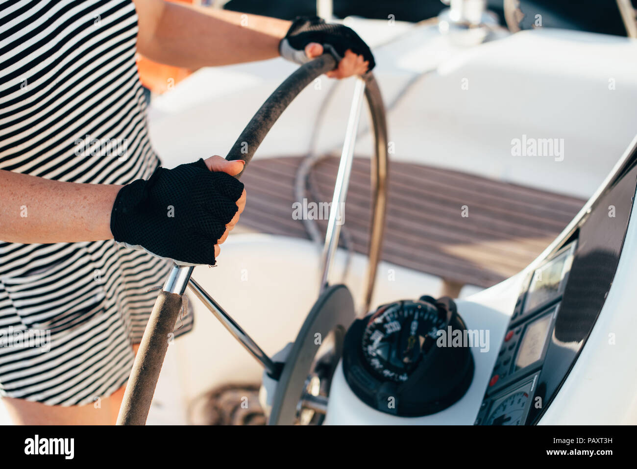 Un uomo detiene una barca di casco con due mani, indossando guanti in estate. Foto Stock