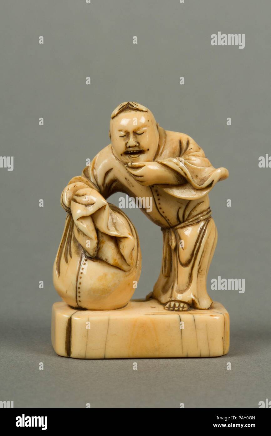 Netsuke di uomo con un sacchetto, in piedi su un blocco. Cultura: il Giappone. Dimensioni: H. 1 5/8 in. (4.1 cm); W. 1 1/8 in. (2,9 cm); D. 3/4 in. (1.9 cm). Data: del XIX secolo. Museo: Metropolitan Museum of Art di New York, Stati Uniti d'America. Foto Stock