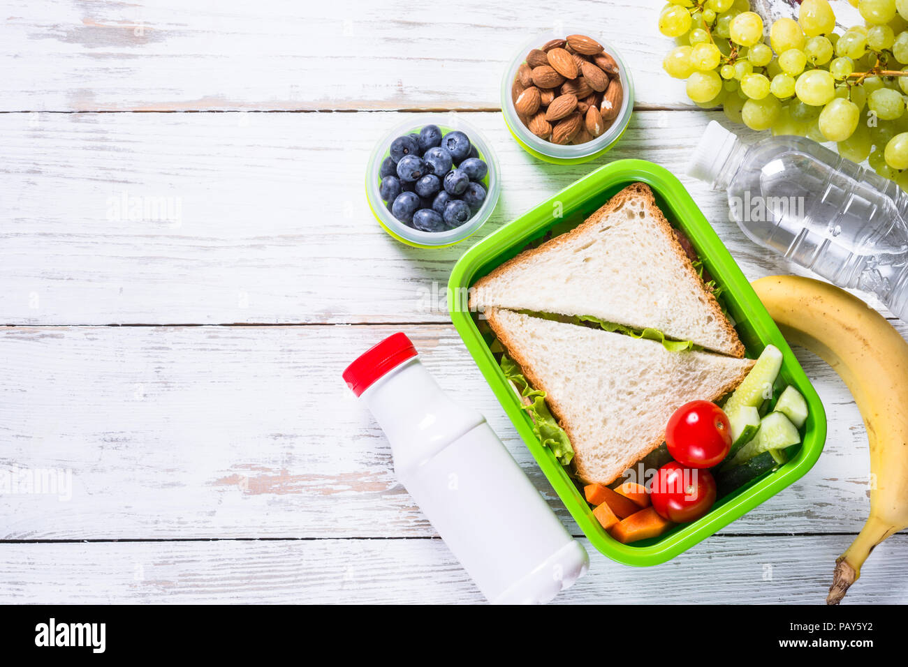 Scatola di pranzo con sandwich, verdure, yogurt, dadi e bacche. Foto Stock