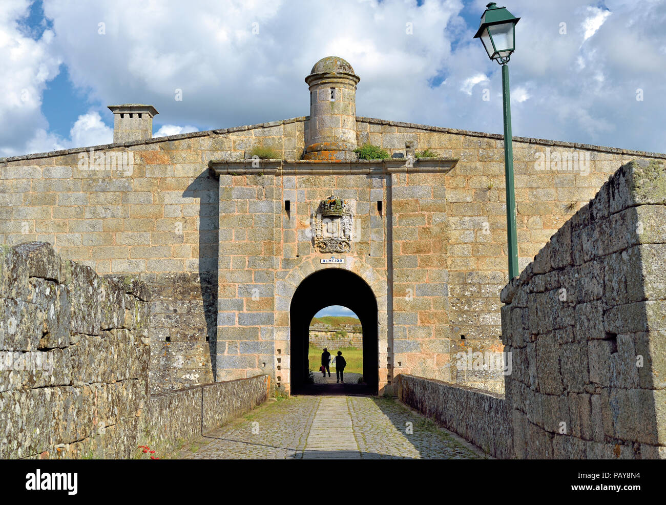 Due persone a piedi attraverso un tunnel di una storica town gate Foto Stock