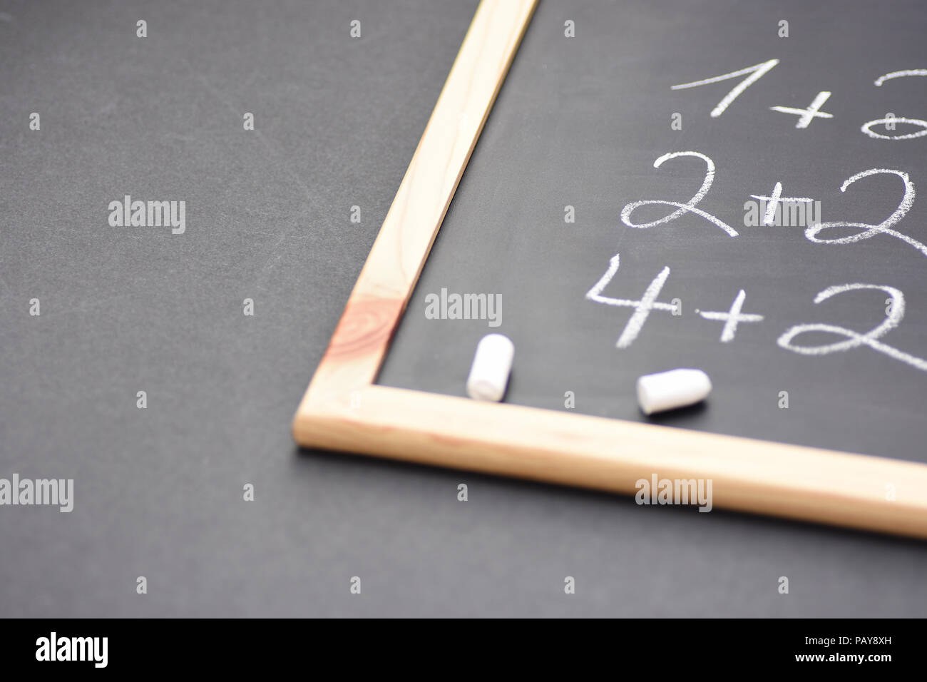 Frammento di lavagna nera con la scritta a mano semplici equazioni matematiche rotti gessi bianchi. Si torna a scuola il concetto di apprendimento dell'istruzione. I Creative Foto Stock