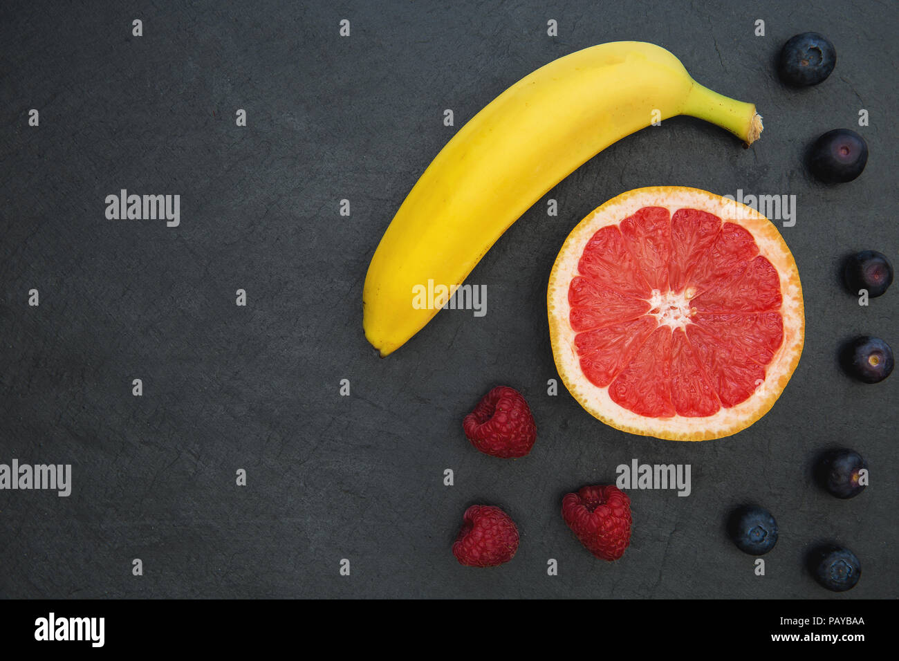 Selezione di frutta sul cibo scuro dello sfondo con spazio di copia Foto Stock