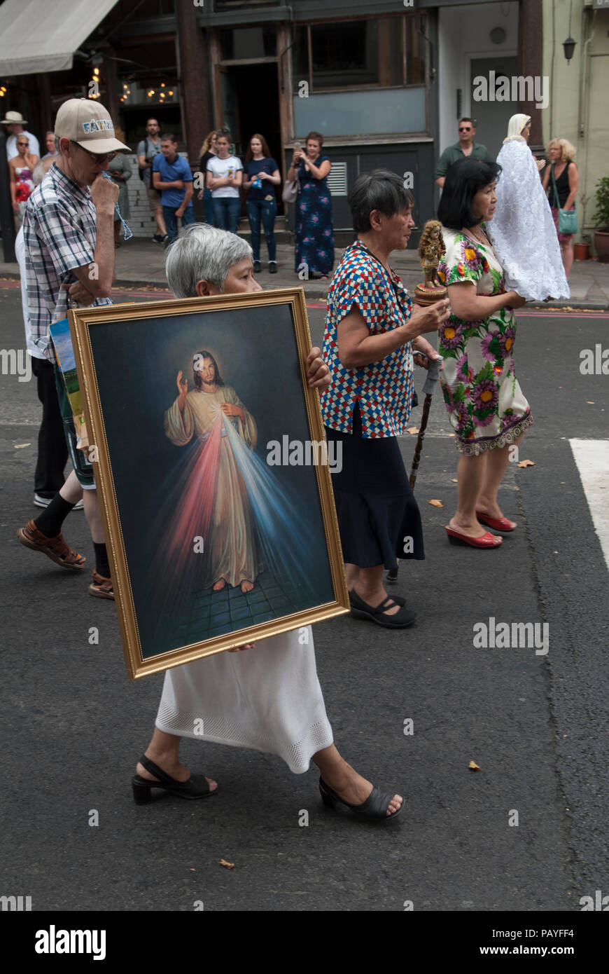 Londra multietnica Regno Unito. I cattolici italiani multiculturali filippini a Londra prendono parte alla processione annuale, una festa religiosa della Chiesa italiana di San Pietro a Clerkenwell. Si trattano intorno all'area trasportando ikon religiosi, quadri e statue. L'evento annuale si svolge a luglio nel centro di Londra nel Regno Unito negli anni '2018 2010 di HOMER SYKES Foto Stock