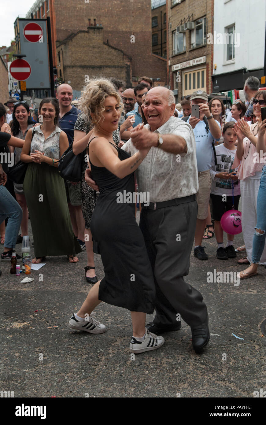 Differenza di età uomo anziano giovane donna che ballano insieme Street party la comunità italiana festeggia a Londra Regno Unito 2018 2010s HOMER SYKES Foto Stock