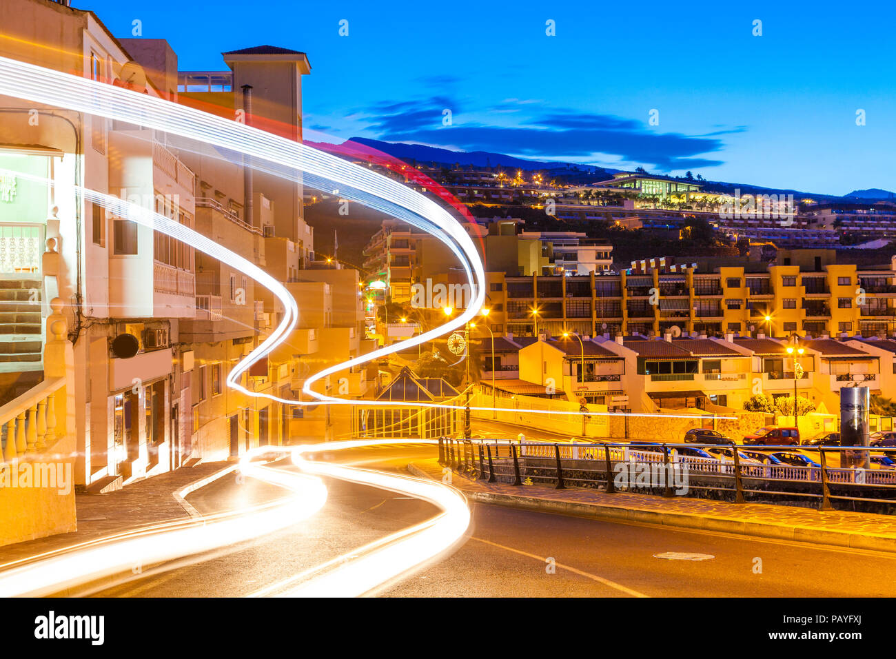 Bella scena notturna con bus e auto sulla traccia la strada in Puerto de Santiago, Tenerife - Spagna Foto Stock