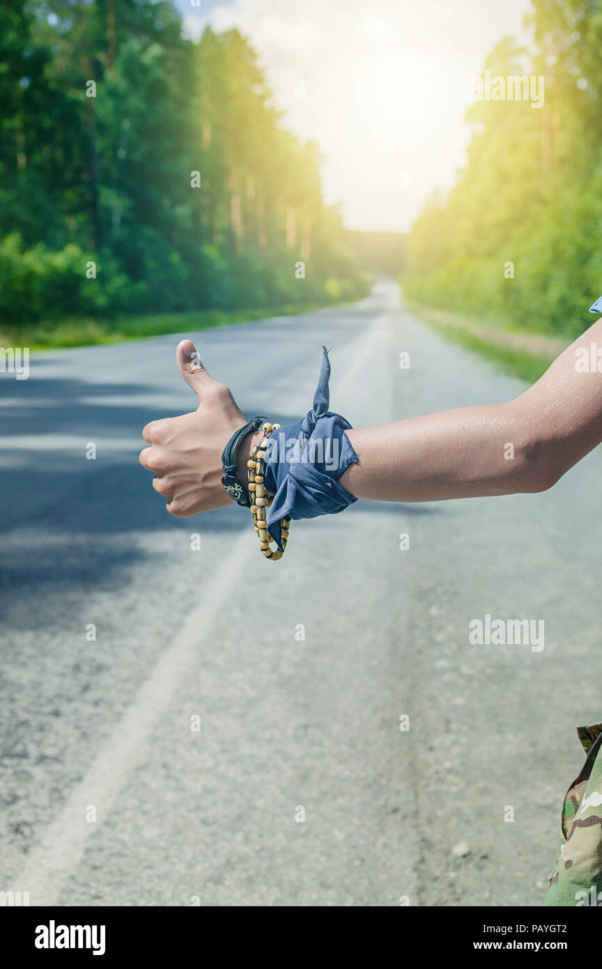 Adolescente mano autostop per il concetto di viaggio. Close-Up. colpo verticale Foto Stock