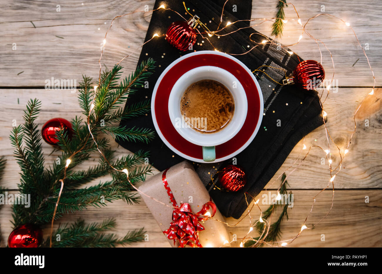 Deliziosa mattina caffè espresso in una coppa di verde di rosso e un piattino, sulla tavola in legno rustico con festosa (Natale, Capodanno) decorazioni, doni Foto Stock