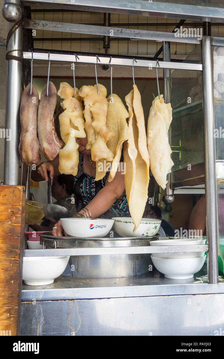 Lingua di bue e la trippa di manzo pendenti da ganci metallici in un ristorante tradizionale nella città di Ho Chi Minh, Vietnam. Foto Stock