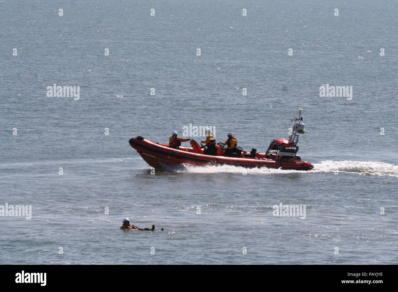 Porthcawl RNLI fuori su un lancio della formazione, mettendo una elevata velocità dello scafo rigido attraverso i suoi passi davanti a una folla impaccato come parte del festival di salvataggio. Foto Stock