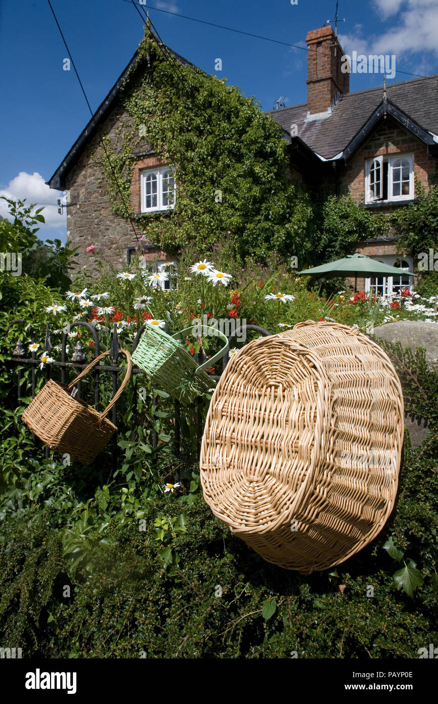 Fine della terrazza cottage in Rhos con varie forme di cestini di vimini appesi per la vendita Foto Stock