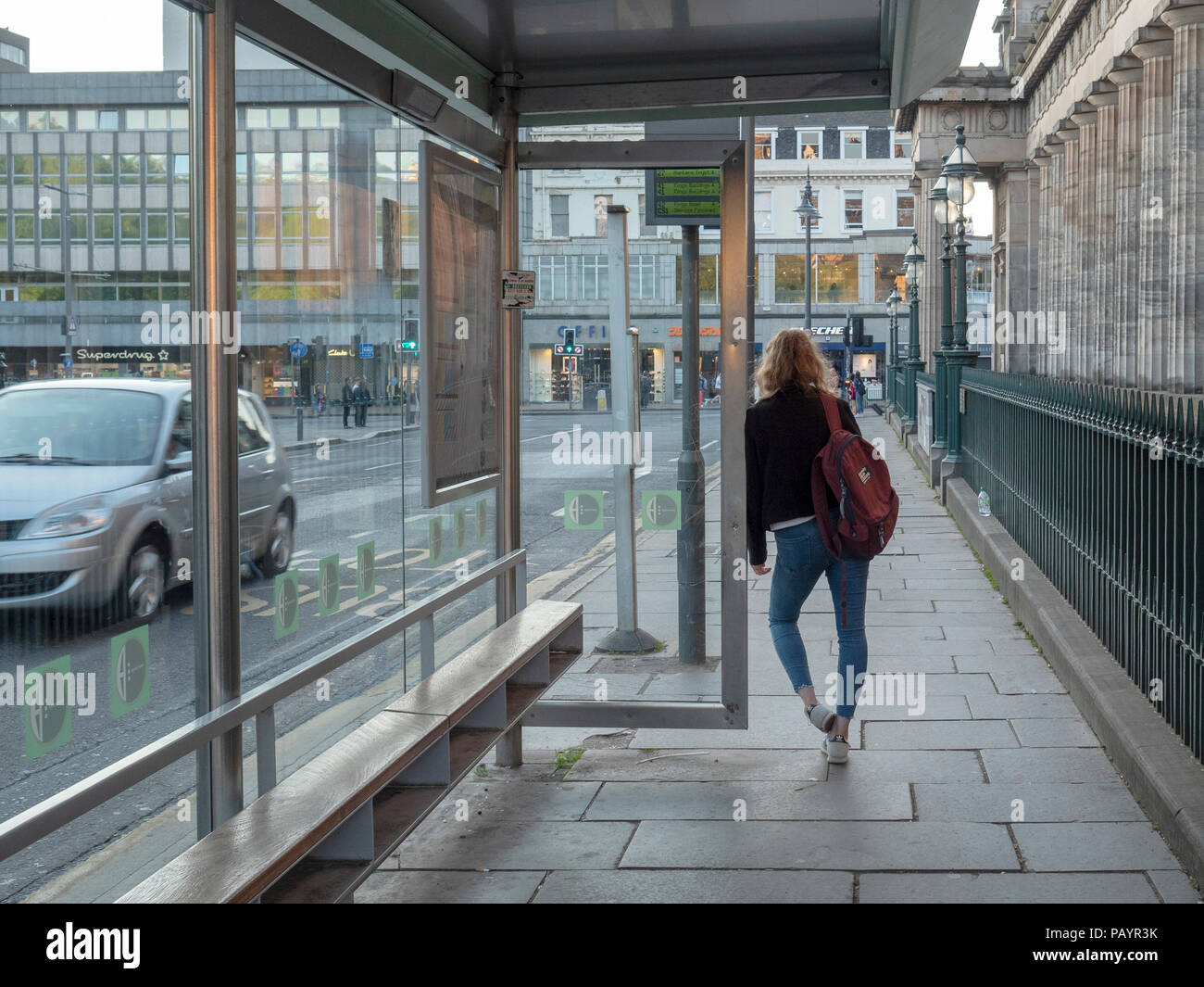 Ragazza in attesa su un autobus con il Tumulo, Edimburgo, Scozia, Regno Unito. Foto Stock