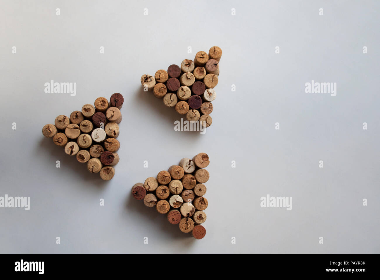 Tre tappi vino triangoli disposti in forma triangolare su sfondo bianco con spazio di copia Foto Stock