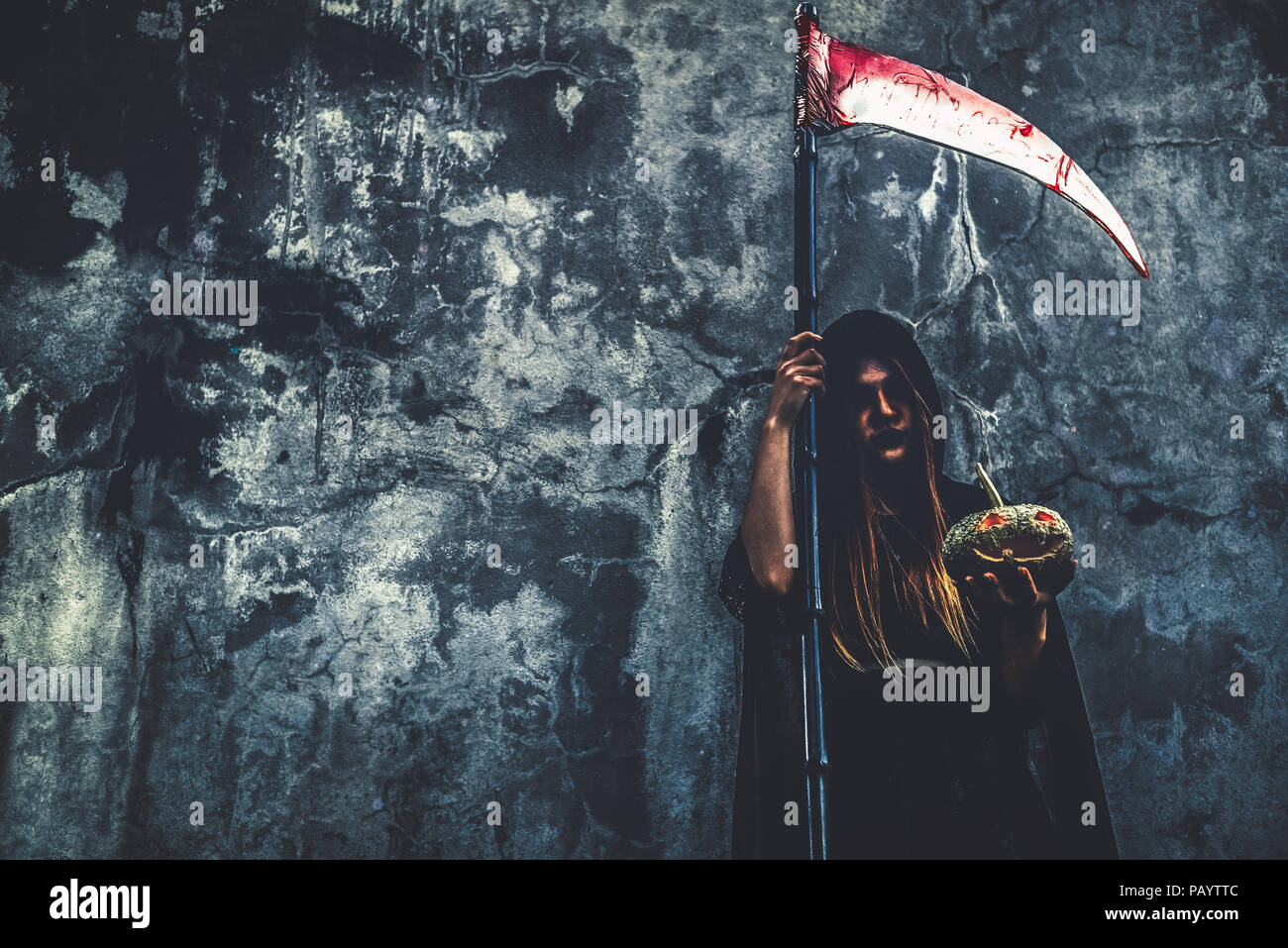 Demon strega con reaper sulla parete grunge background. Halloween e la concezione religiosa. Demon angel e tema di Satana. Foto Stock