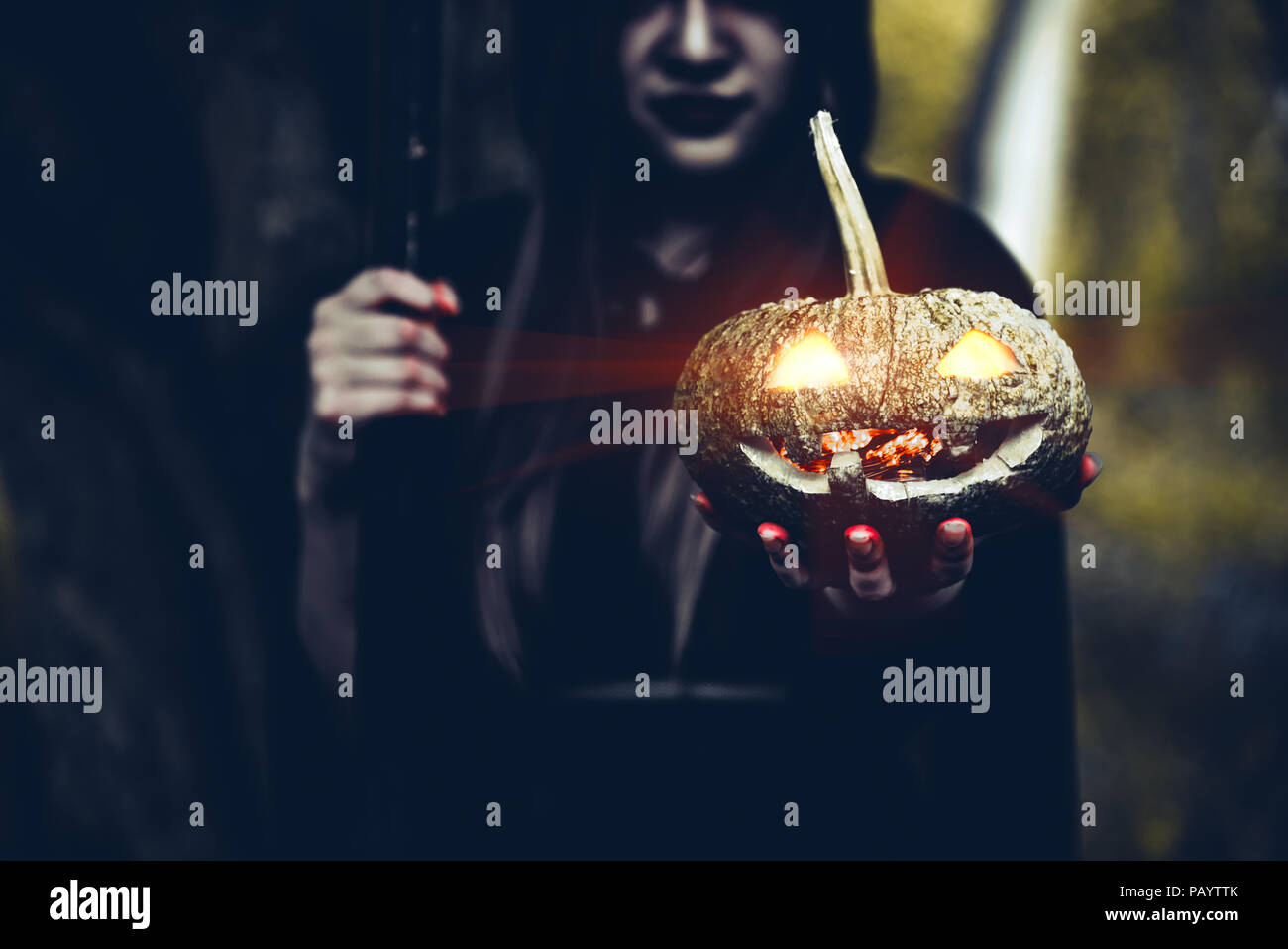 Zucca in mano della strega. Vecchia donna tenendo la zucca in foresta scura. Il giorno di Halloween e il mistero del concetto. La fantasia del tema di magic. Foto Stock