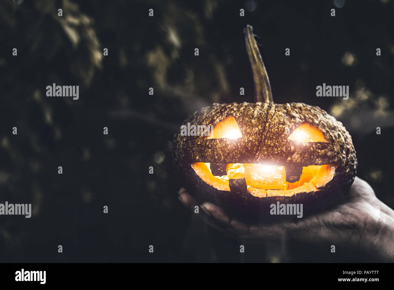 Zucca di Halloween in mano, le ferie e il concetto di religione. Ghost in tema di zucca. La stregoneria e mistero e magia del tema. Foto Stock