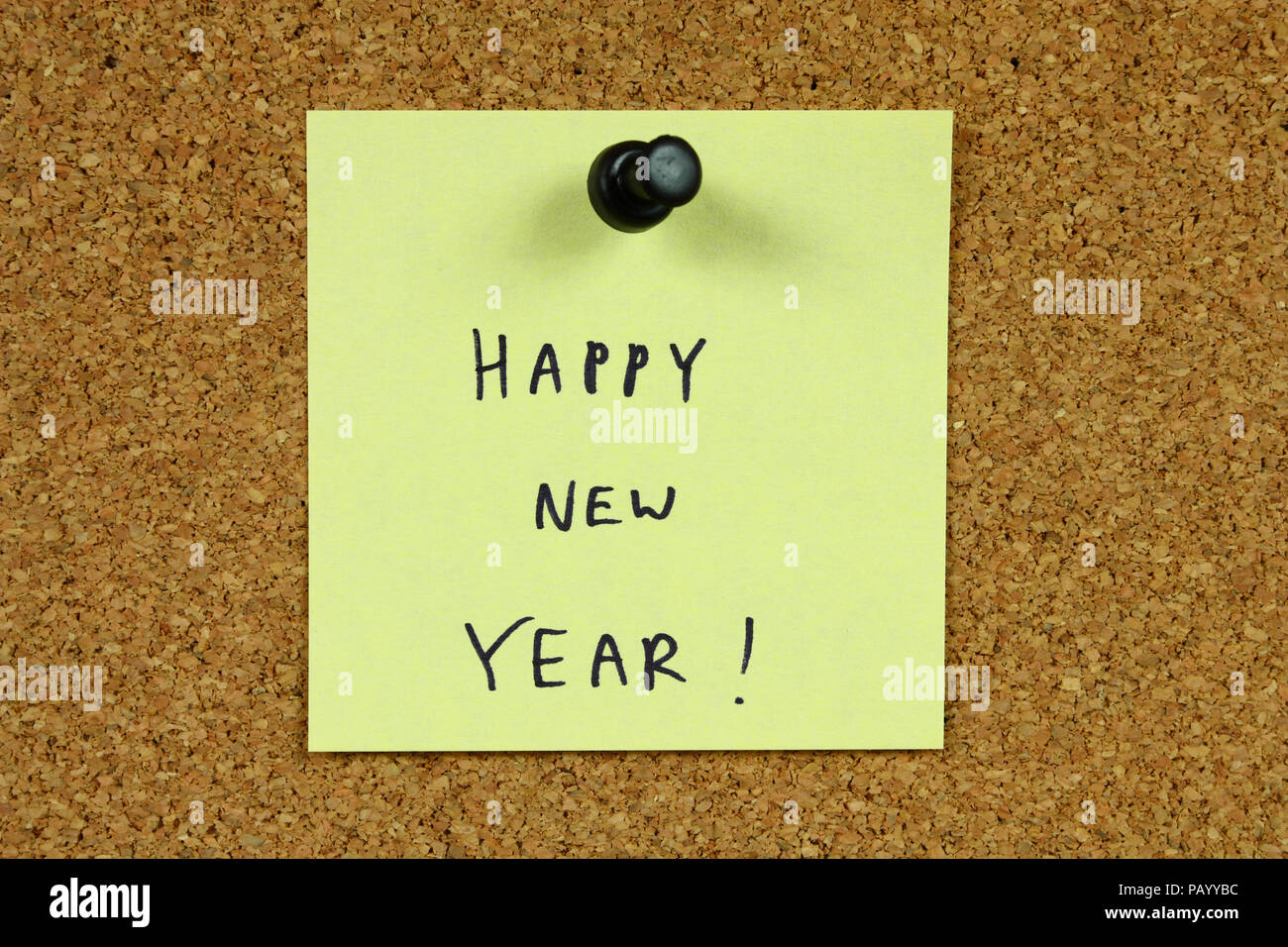 Giallo piccola nota adesiva su un ufficio cork bulletin board. Felice Anno Nuovo! Foto Stock