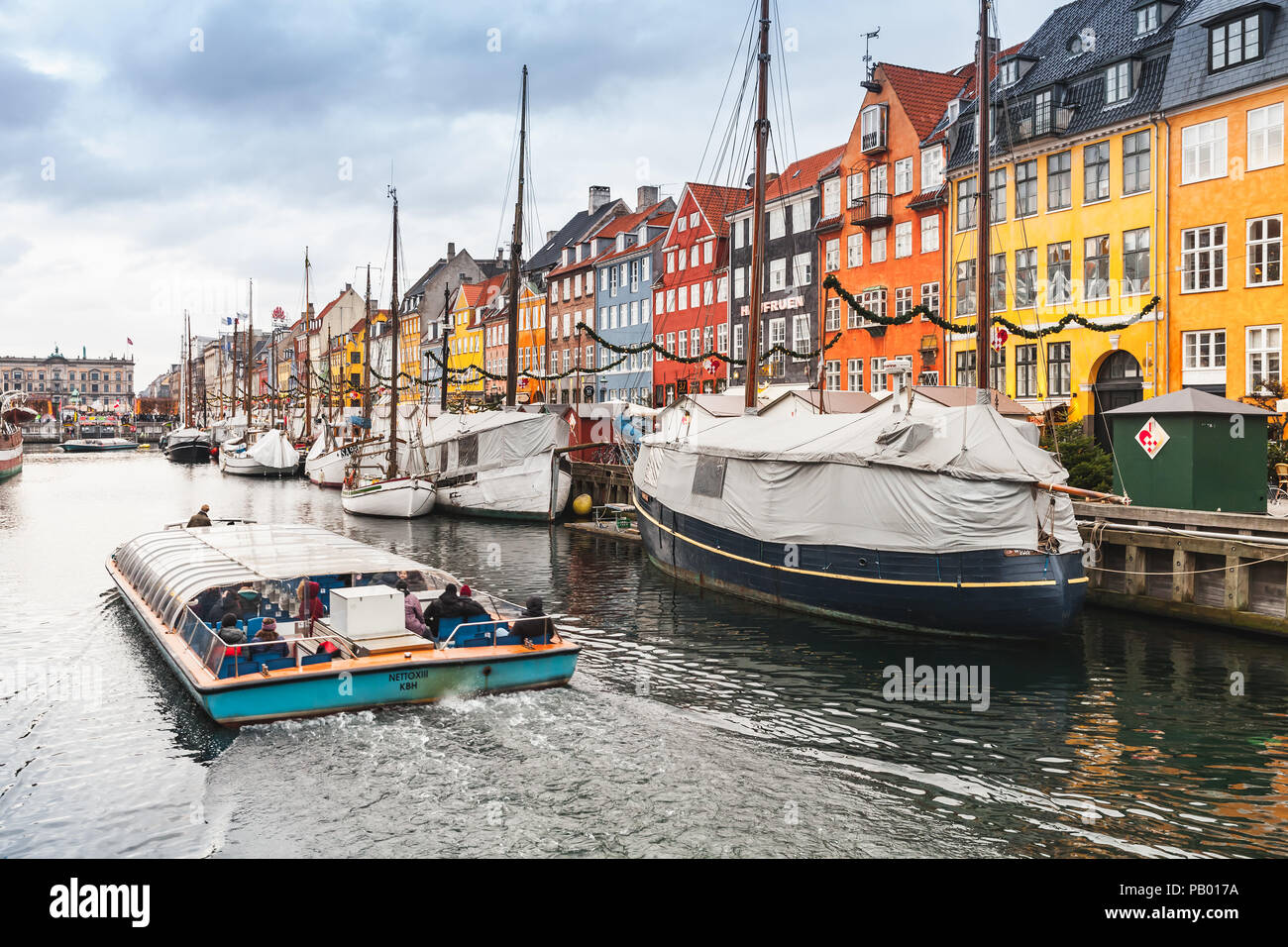 Copenhagen, Danimarca - 10 dicembre 2017: imbarcazione da diporto con i passeggeri. Nyhavn o porto nuovo, è un monastero del XVII secolo waterfront, canal e popolare gita Foto Stock Copenhagen, Danimarca - 10 dicembre 2017: imbarcazione da diporto con i passeggeri. Nyhavn o porto nuovo, è un monastero del XVII secolo waterfront, canal e popolare gita Foto Stock