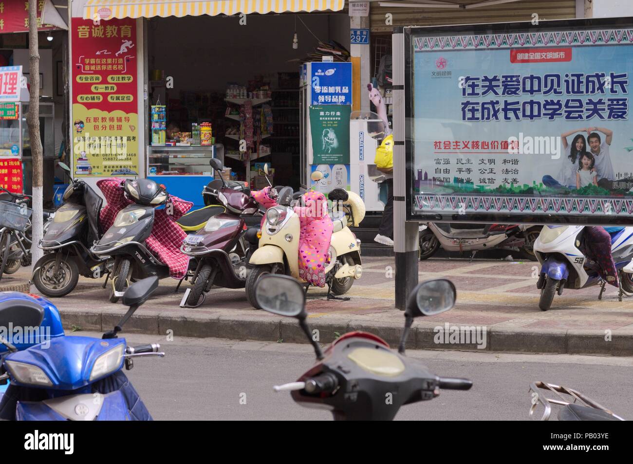 Kunming, Yunnan, Cina - 30 dicembre 2017: Scooter cinese di fronte a un mercato Foto Stock