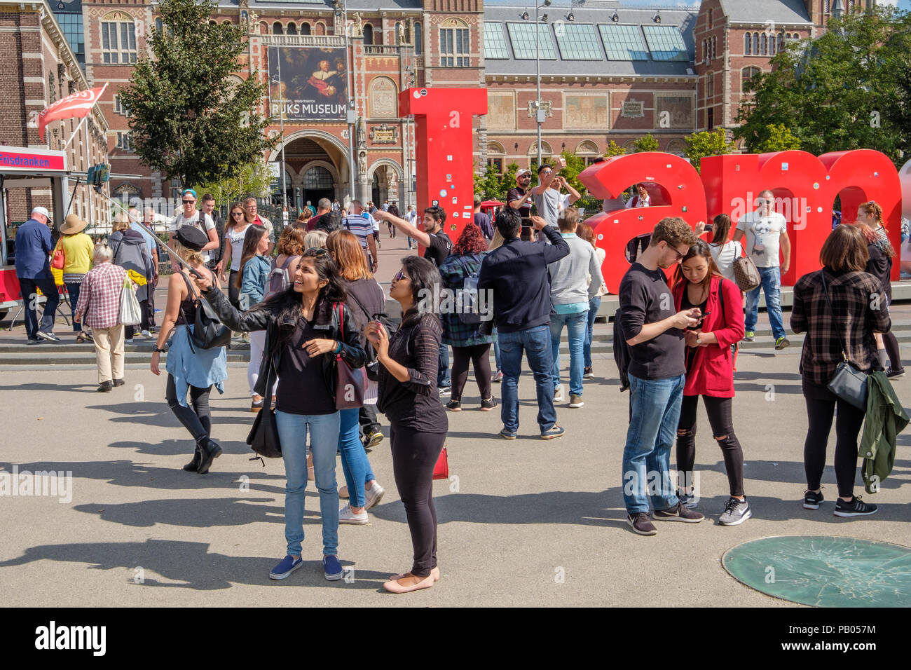 I turisti con selfie stick su piazza dei musei di Amsterdam Foto Stock