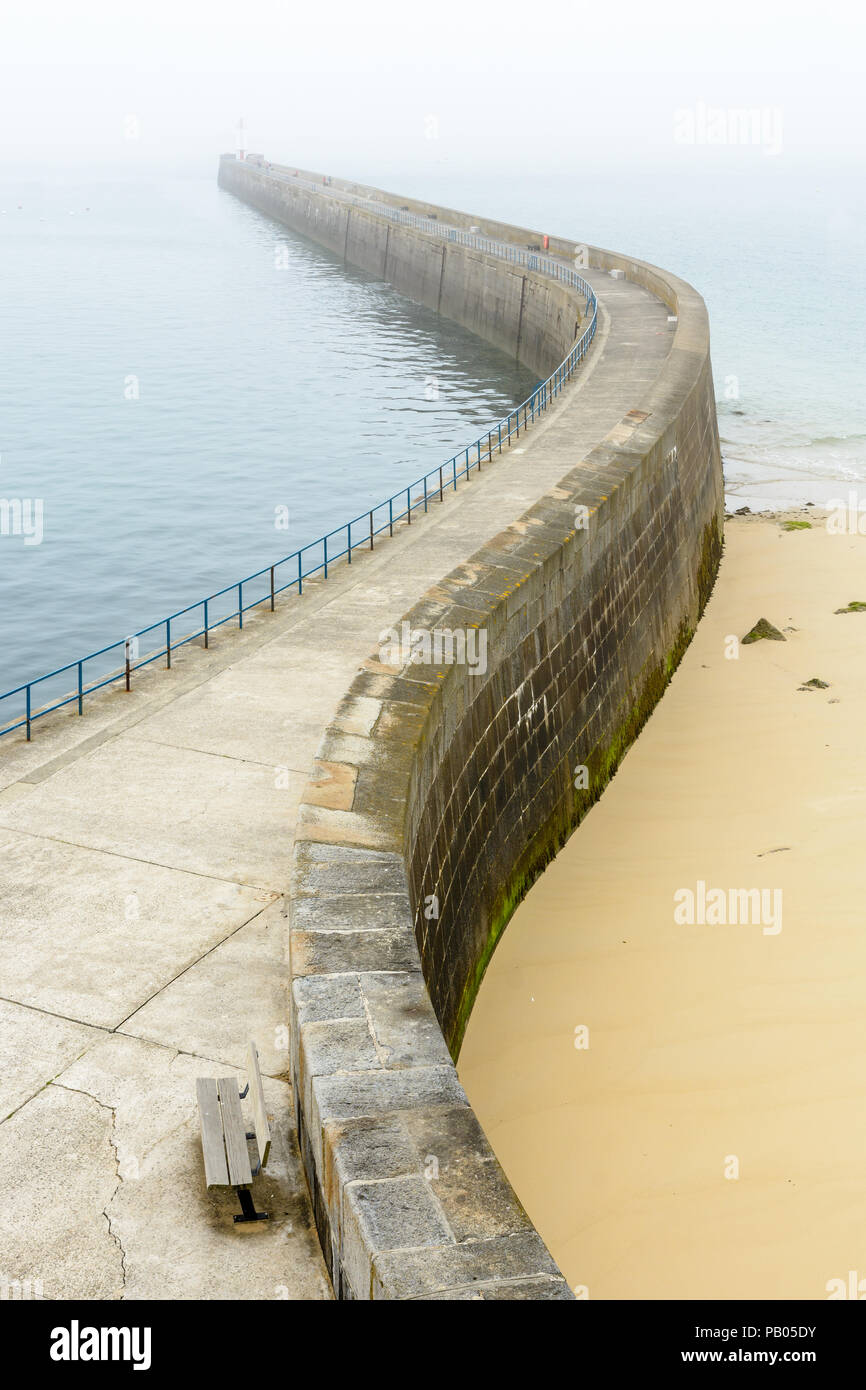 La Mole des Noires, il lungo frangiflutti delle mura di cinta della città di Saint Malo in Bretagna, Francia, da una mattinata nebbiosa. Foto Stock