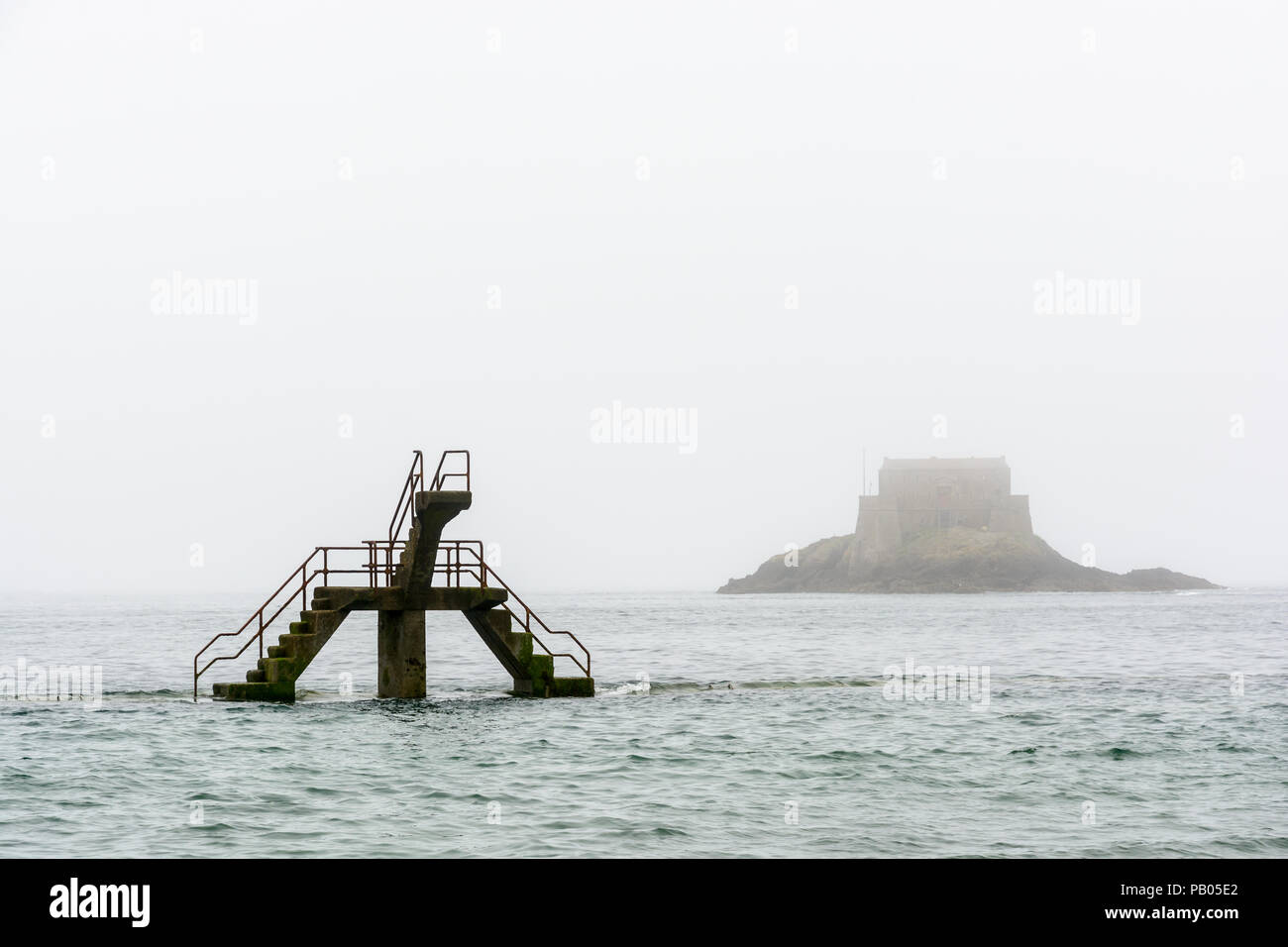 La piattaforma di immersione delle maree piscina di Bon Secours beach, a Saint-malo, Francia, da un nebbioso giorno con il Petit essere isola in background. Foto Stock