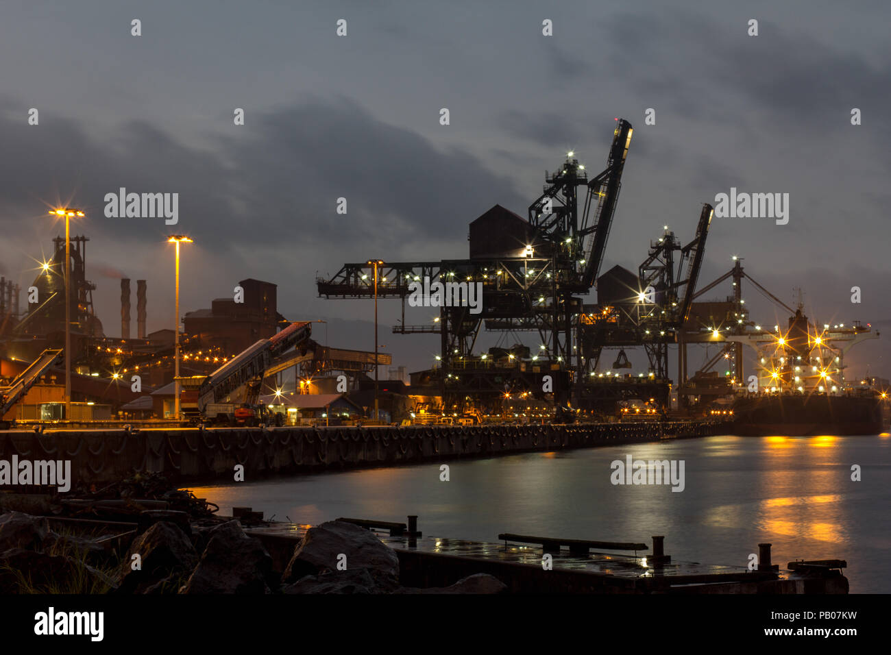 Porto industriale del carbone e del minerale di ferro nave da trasporto presso un porto australiano sul bagnato oscura notte di tempesta Foto Stock