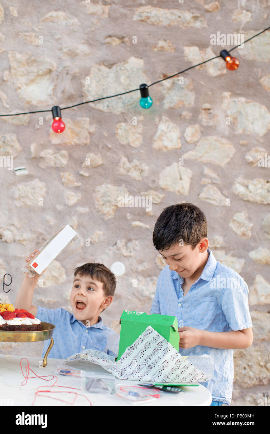 Due ragazzi di unwrapping regali di compleanno Foto Stock