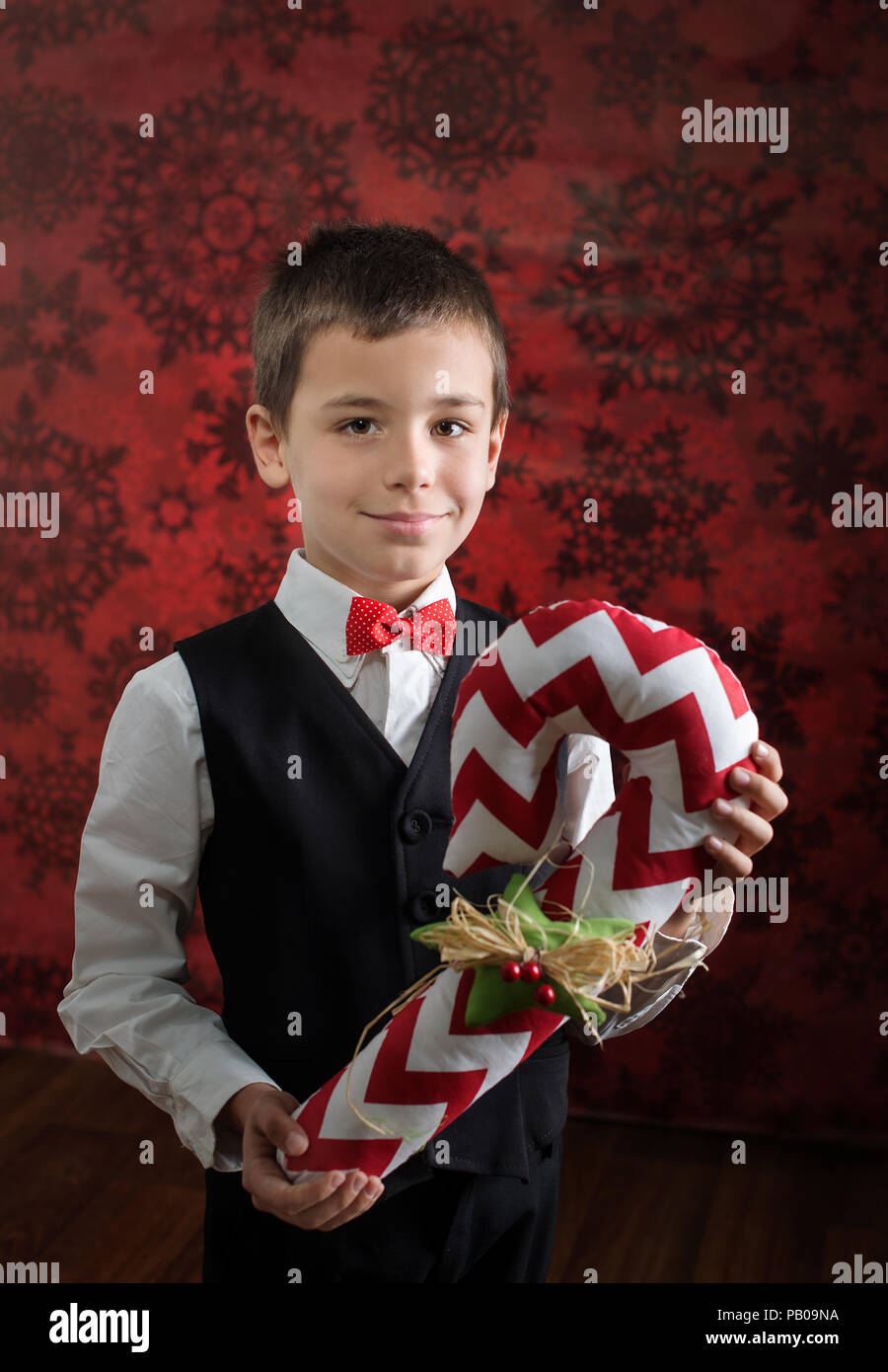 Ritratto di un ragazzo sorridente tenendo un avvolto regalo di Natale Foto Stock